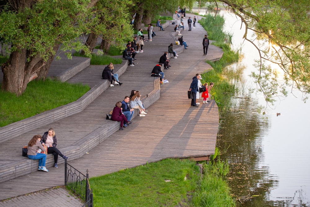 people walking on sidewalk near river during daytime