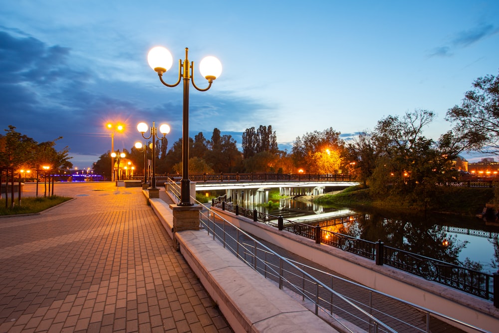 a walkway next to a body of water at night