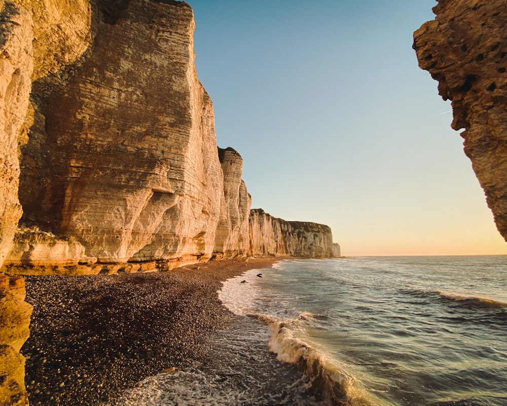 brown rock formation beside sea during daytime