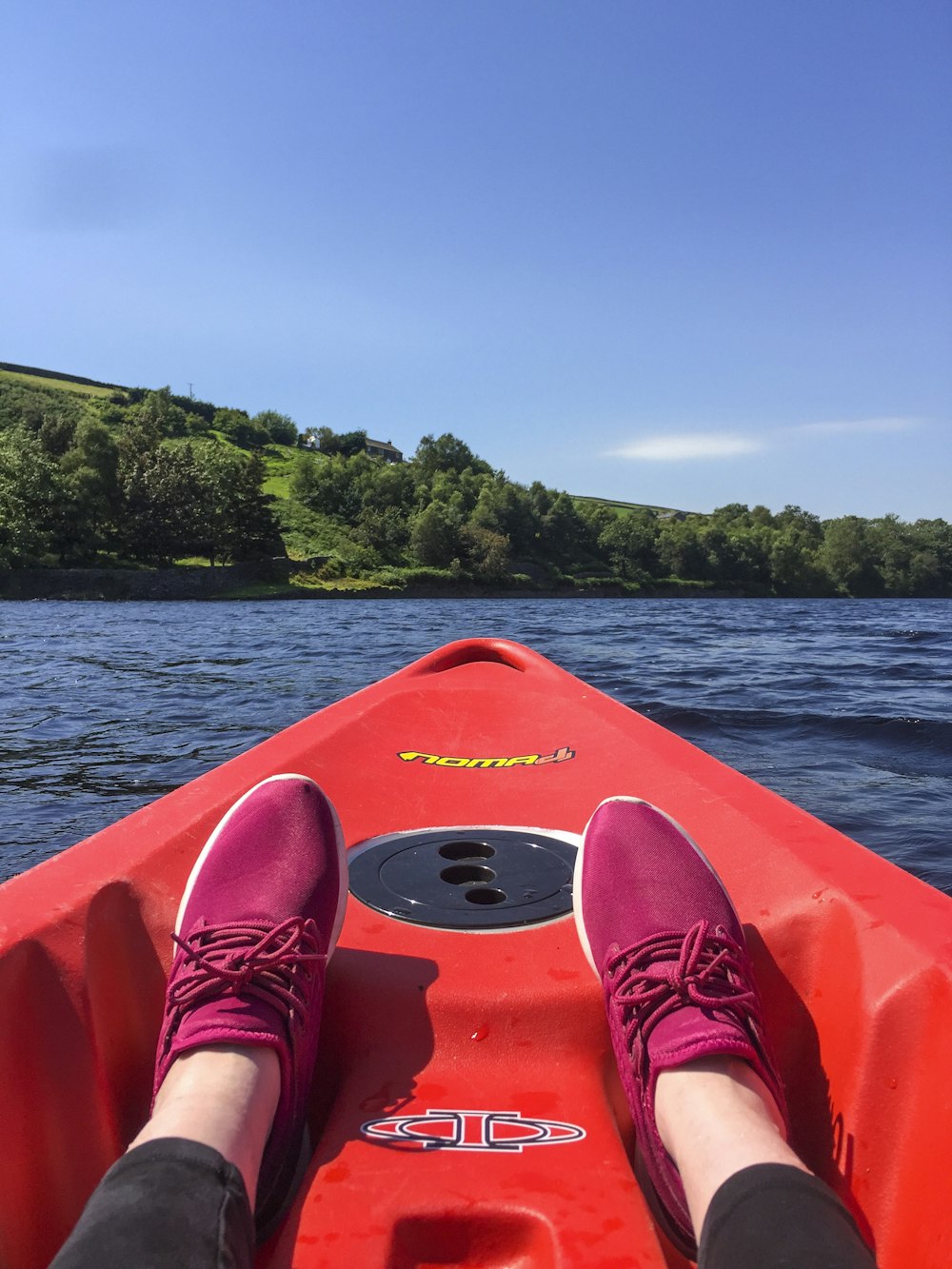 person in red kayak on body of water during daytime