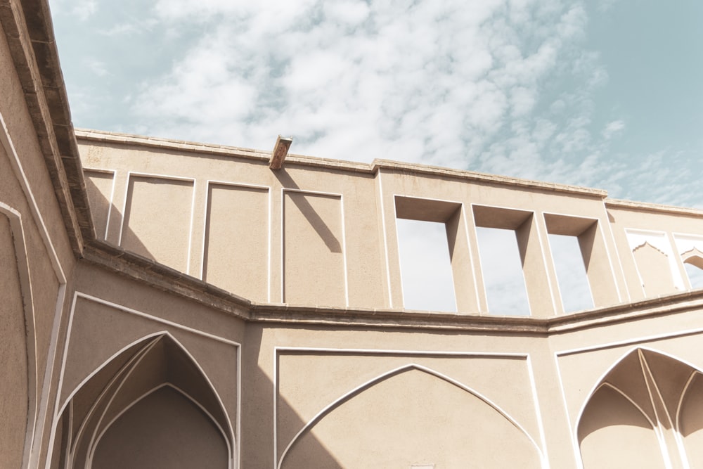 beige concrete building under white clouds during daytime