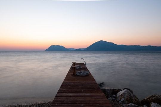 brown wooden dock on body of water during daytime in Patras Greece