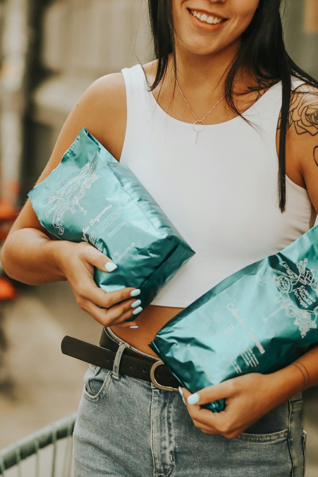 woman in white tank top holding green plastic pack