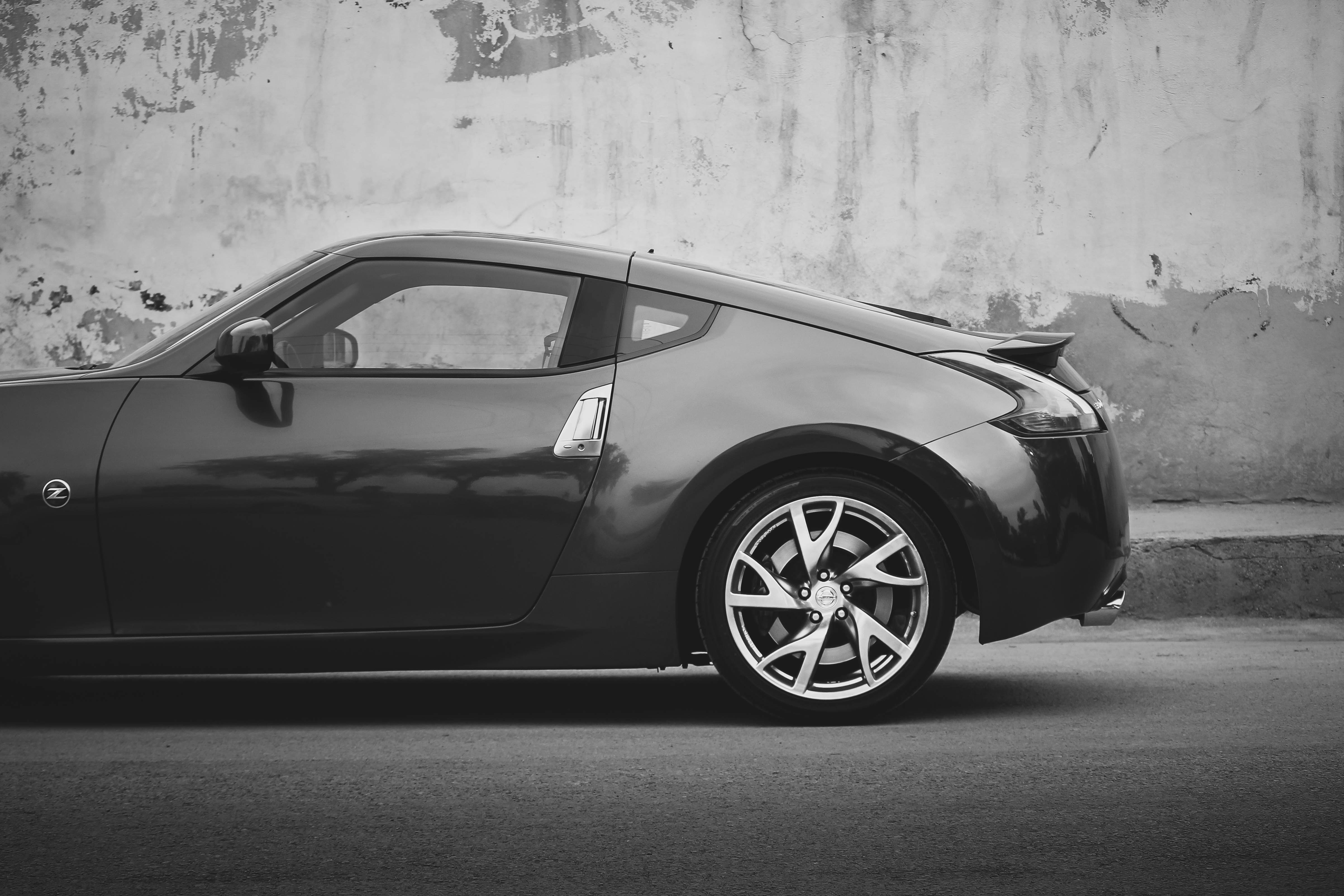 black porsche 911 parked on gray concrete pavement nissan teams background