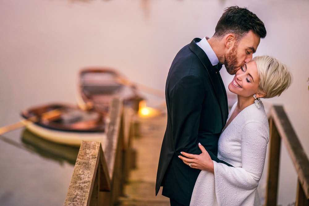 man in black suit and woman in white dress