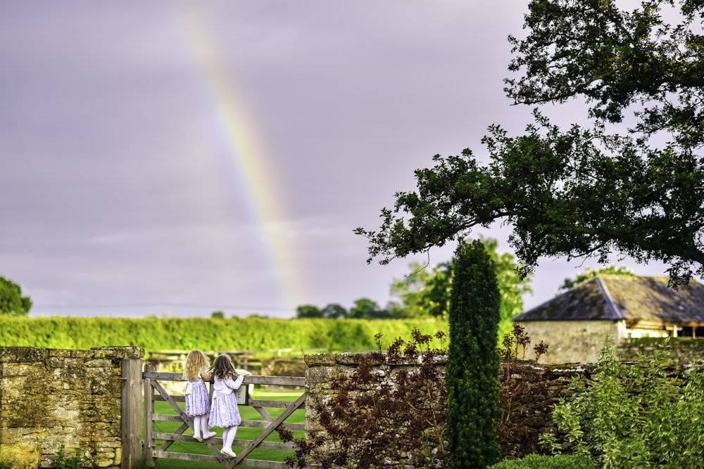 man in white shirt standing near green tree during daytime