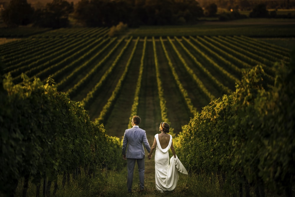 homme et femme marchant sur le champ d’herbe verte pendant la journée