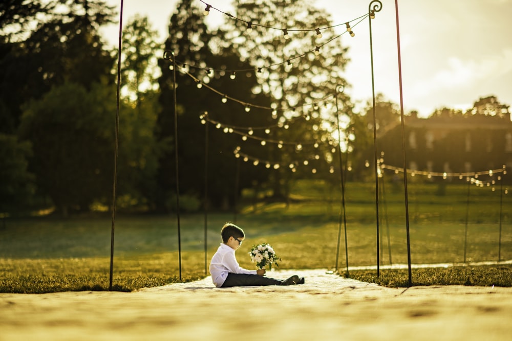 man in white shirt sitting on ground during daytime