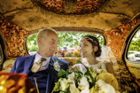 The groom and bride sharing a joyful moment inside the stylish, eco-friendly taxi.