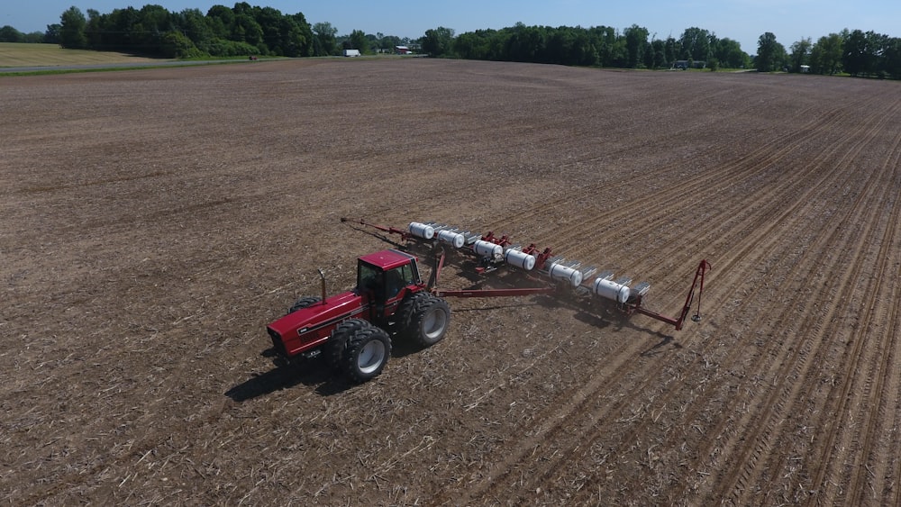 red tractor on brown field during daytime