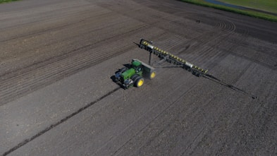 green and black tractor on gray asphalt road during daytime