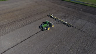 green and black tractor on gray asphalt road during daytime