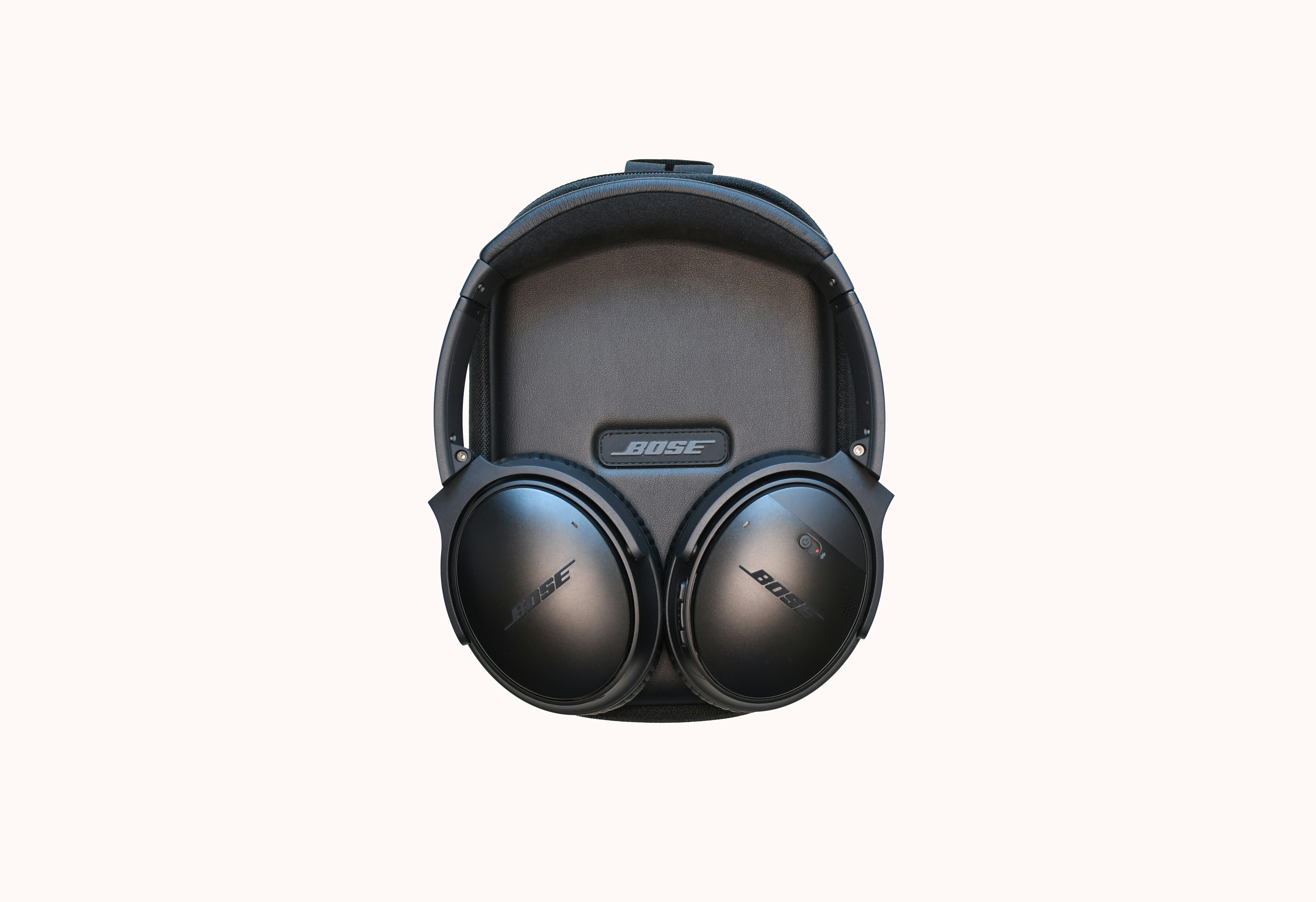 Headphones folded in carrying case on clean surface, product detail photography