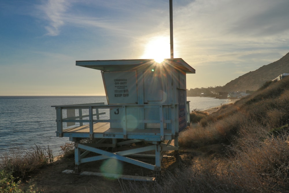 white wooden lifeguard house on seashore during daytime