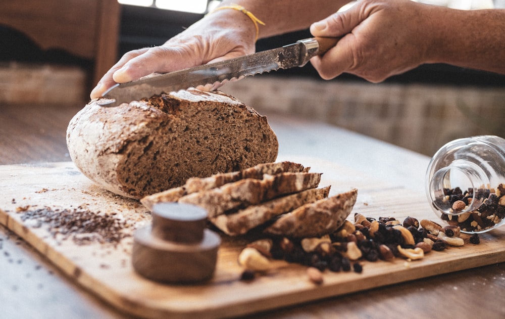 person holding knife slicing chocolate cake