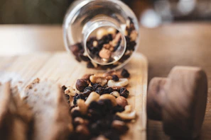 Assorted dried fruits and nuts spilling from a burlap sack onto a cream cloth