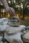 Hands placing interlocking stone pavers along a modern walkway
