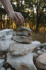 Hands placing interlocking stone pavers along a modern walkway