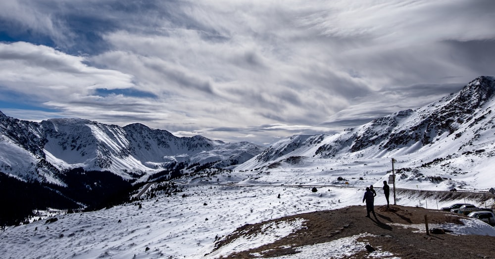 personne debout au sommet de la montagne pendant la journée