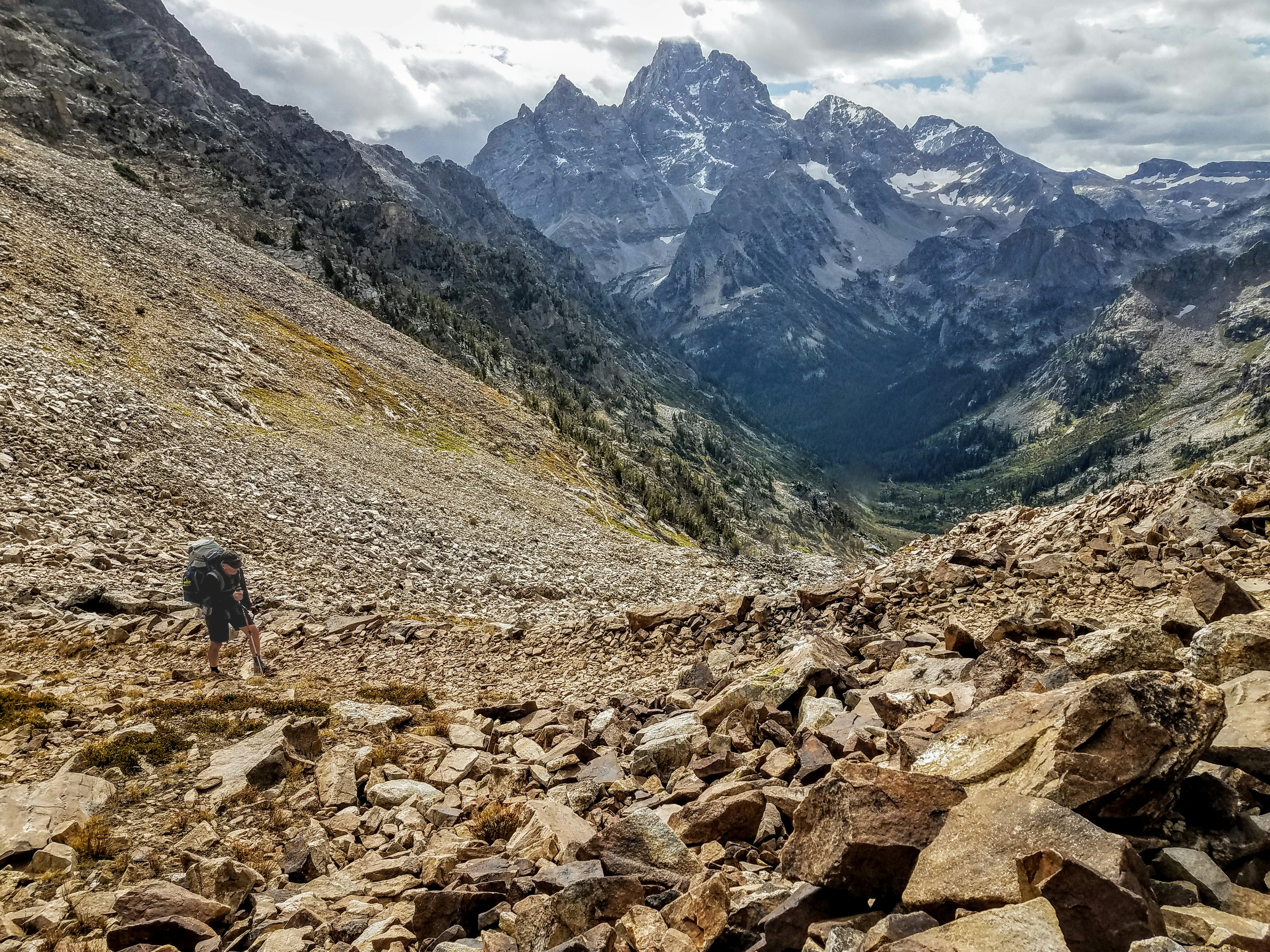 person walking on rocky road near mountains during daytime
