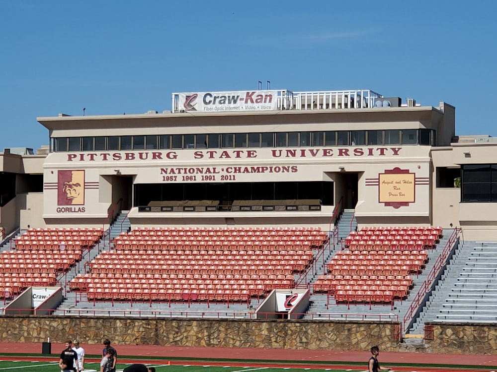 people sitting on stadium bench during daytime