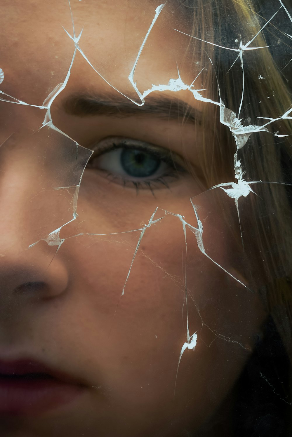 a close up of a person's face with broken glass