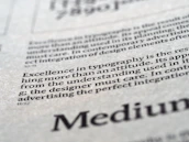 Close-up of refined typography on textured paper with taupe accents, conveying premium quality.