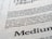 Close-up view of printed text on a textured paper surface. The focus is on the sentence 'Excellence in typography is the result of nothing more than an attitude.' The typeface and layout suggest a refined attention to typographic detail.
