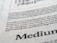 Close-up view of printed text on a textured paper surface. The focus is on the sentence 'Excellence in typography is the result of nothing more than an attitude.' The typeface and layout suggest a refined attention to typographic detail.
