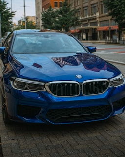 A sleek silver BMW parked on a city street, captured in bright natural light showcasing its pristine condition.