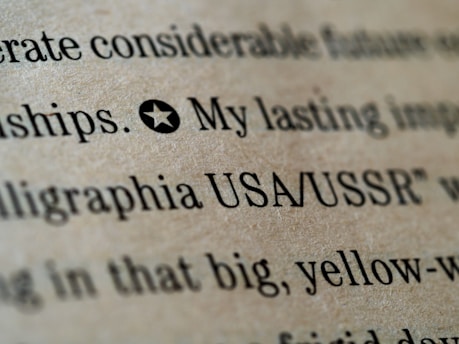 Close-up of printed text on a textured brown paper, with words like 'USA/USSR' and a star symbol preceding the text.