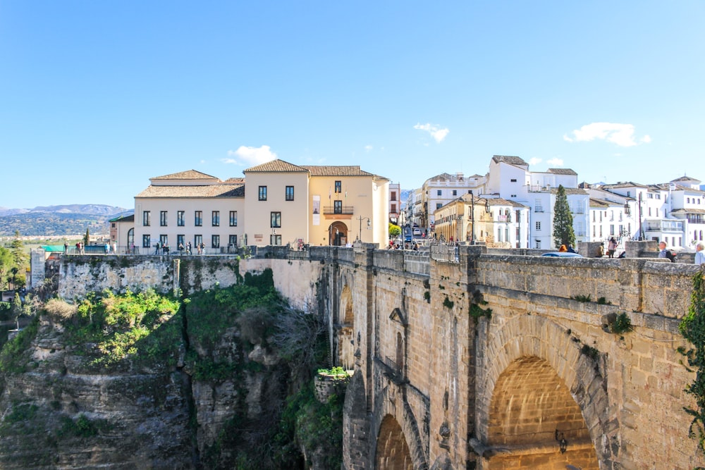 Pont en béton brun près d’un bâtiment en béton blanc pendant la journée