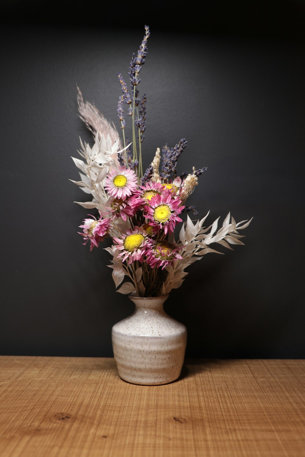Fleur blanche et violette dans un vase en céramique blanche