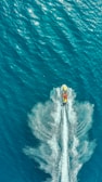 A vibrant photo of a bright red jet ski speeding across clear blue water under a sunny sky.