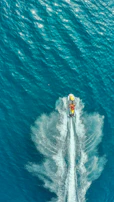Close-up of a jet ski cutting through crystal-clear waves with water splashing energetically.