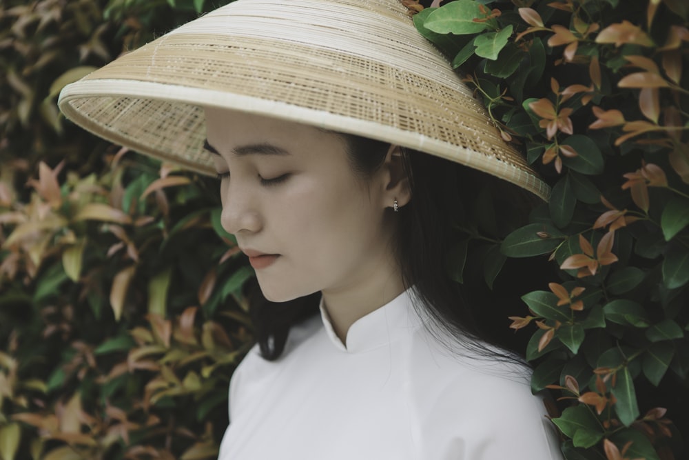 woman in white shirt wearing brown straw hat