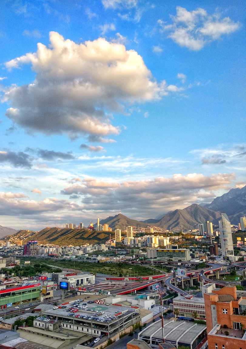 city buildings under blue sky and white clouds during daytime
