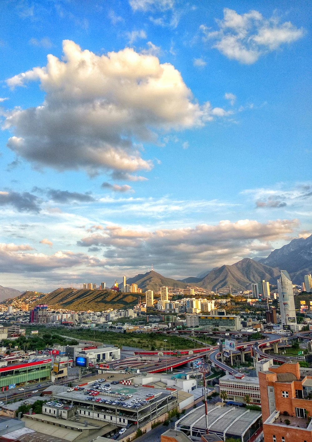 city buildings under blue sky and white clouds during daytime