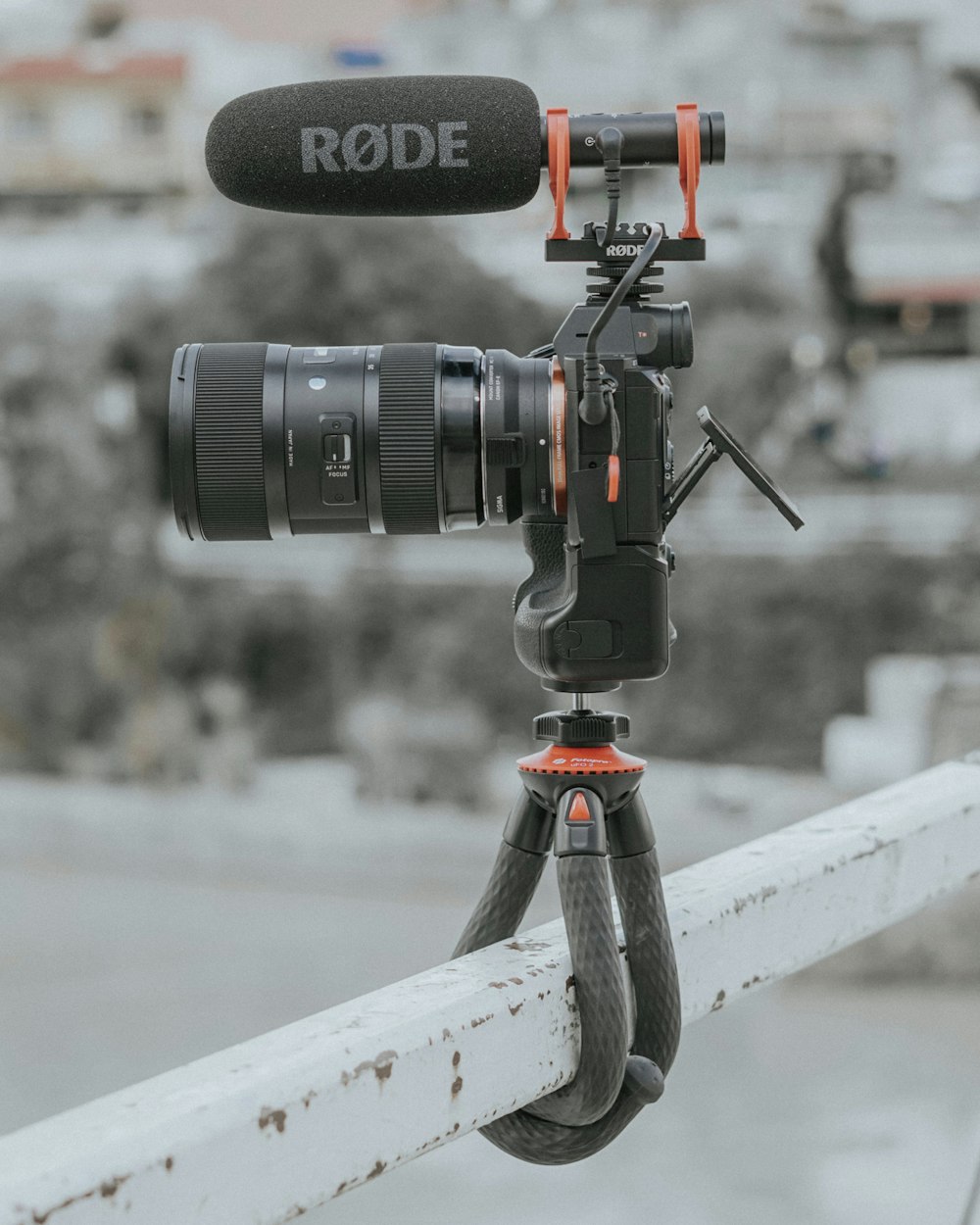 black dslr camera on white wooden fence