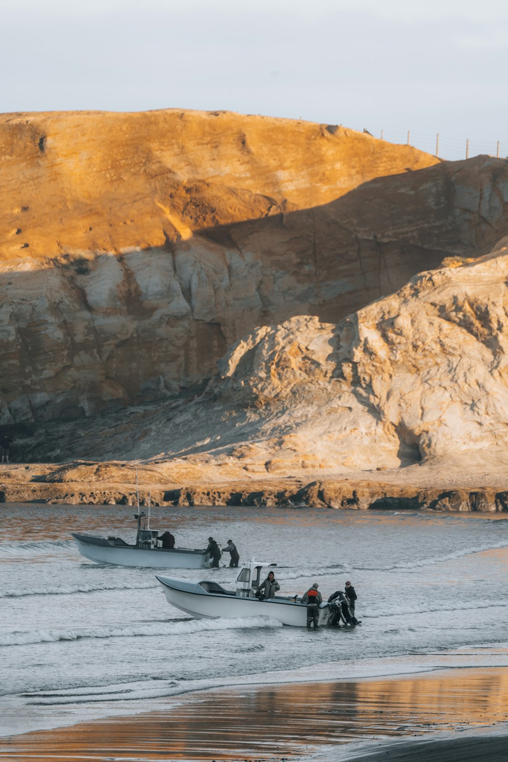 people riding on white kayak on beach during daytime