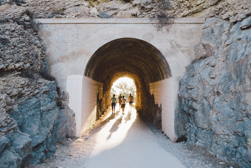 a group of people walking through a tunnel