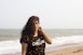 woman in black and white tank top standing on beach during daytime
