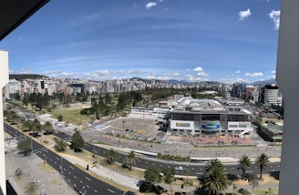 A wide-open commercial land parcel with nearby roads and city skyline in the background.