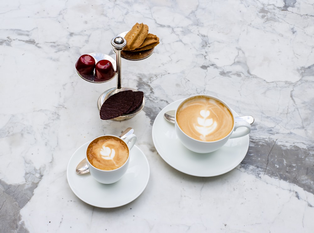 two cups of cappuccino on a marble table