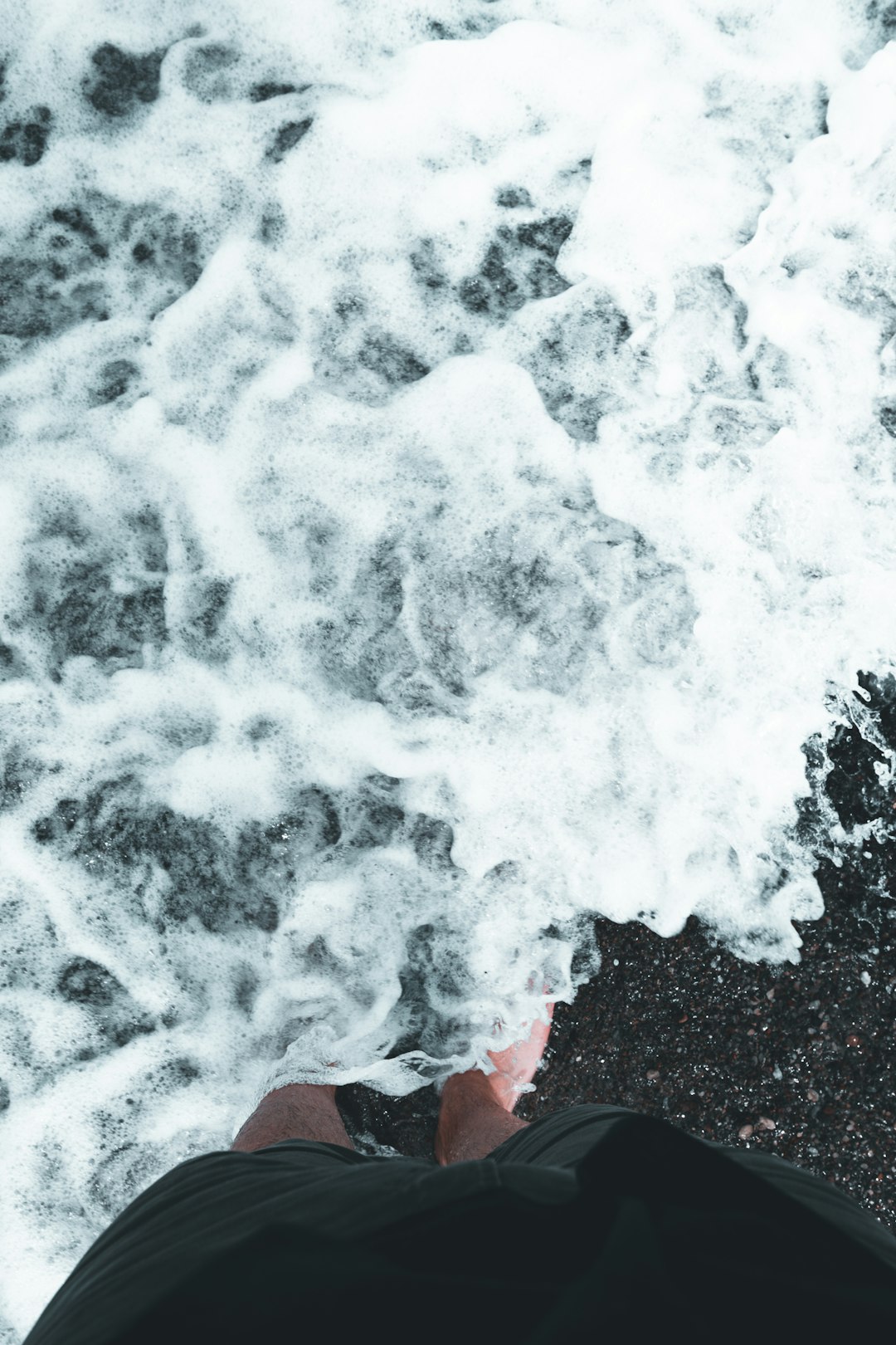 person in red jacket and blue denim jeans standing on water