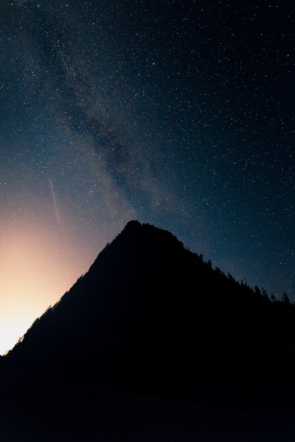 silhouette of mountain under starry night