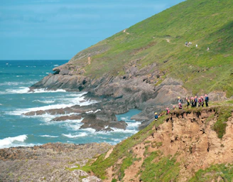 A group of players strategizing together near a coastal cliff in the game.