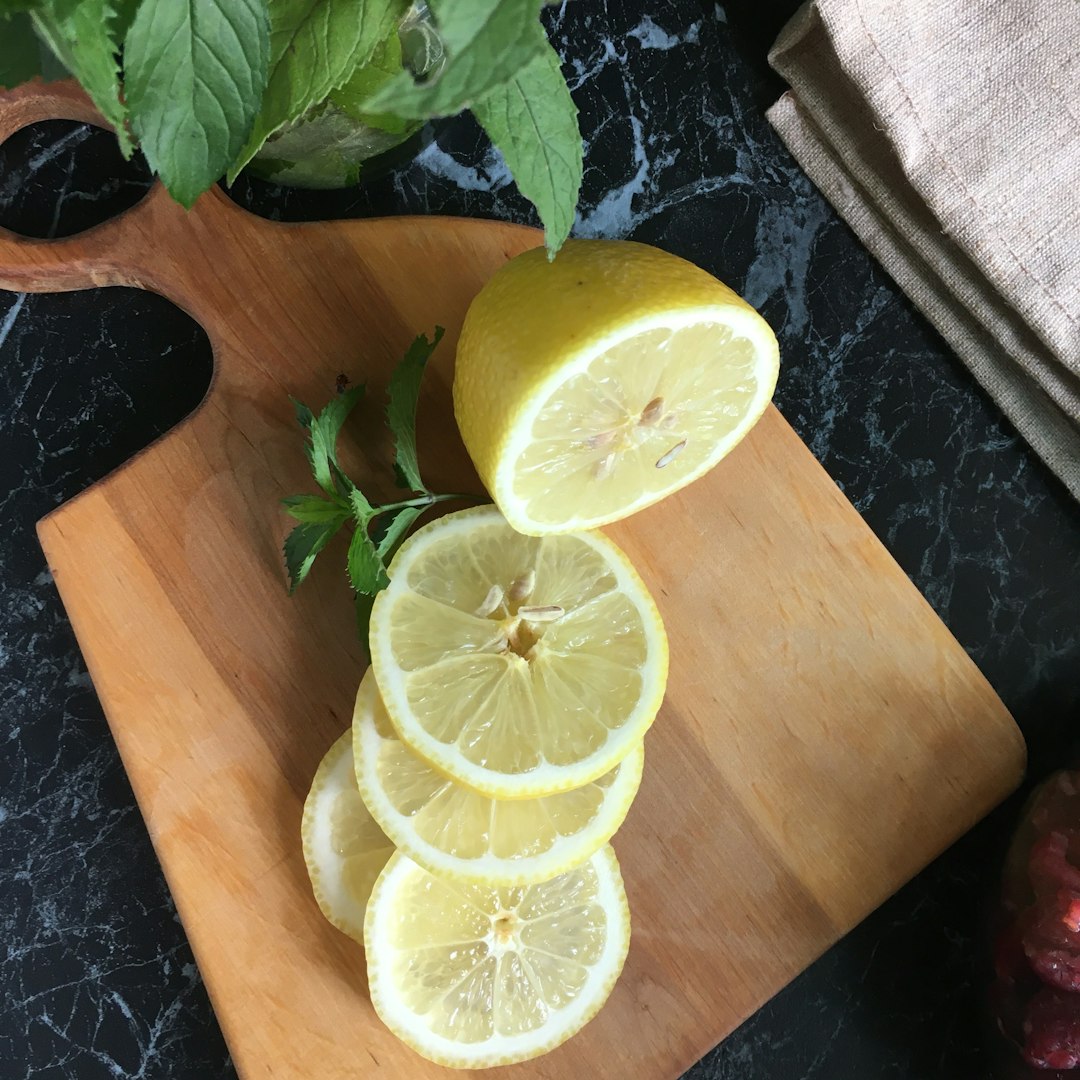 sliced lemon on brown wooden chopping board