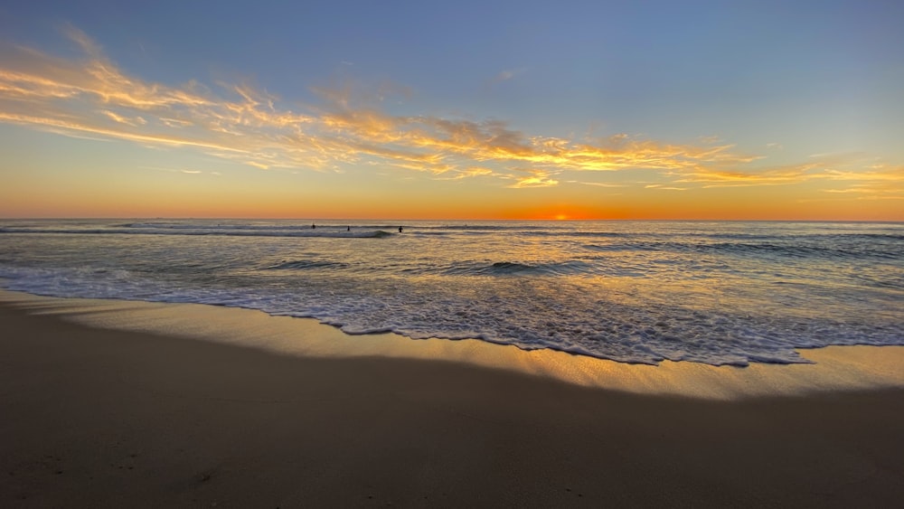 sea waves crashing on shore during sunset