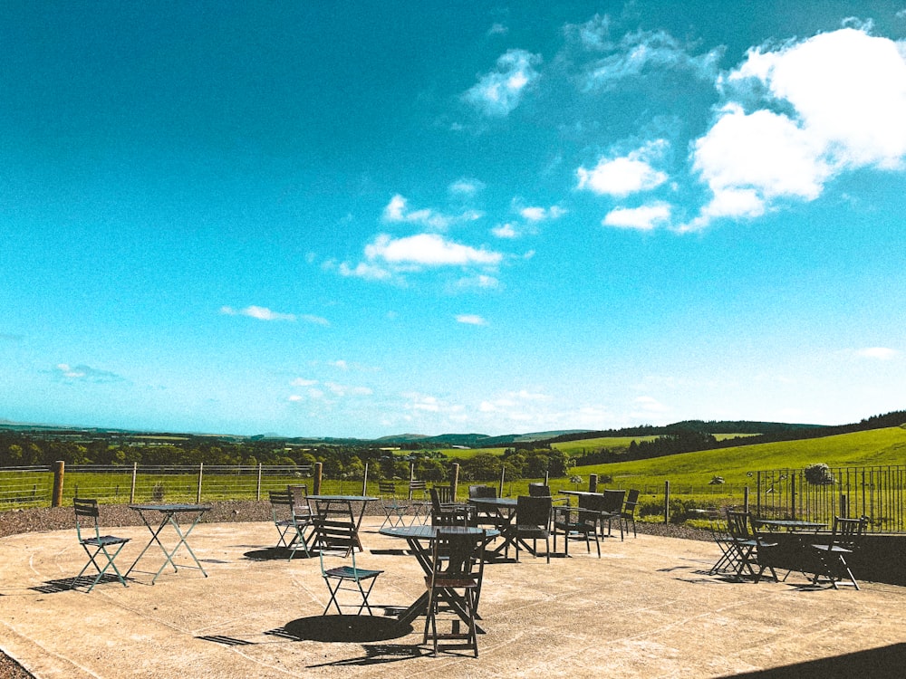 black metal table and chairs on brown sand during daytime